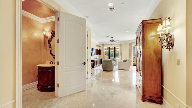 corridor featuring light marble finish flooring, crown molding, a sink, and recessed lighting