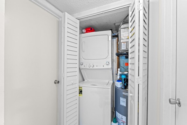 896 N Federal Hwy Unit 121, Lantana, FL 33462 - laundry room with stacked washer / dryer, electric water heater, and a textured ceiling