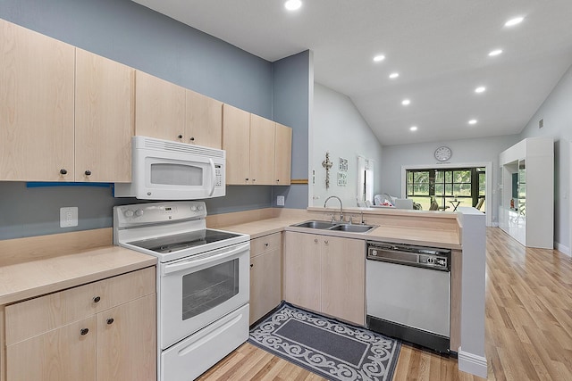 3839 Coco Loba Ln, Boynton Beach, FL 33436 - kitchen featuring white appliances, light brown cabinets, a sink, a peninsula, and vaulted ceiling