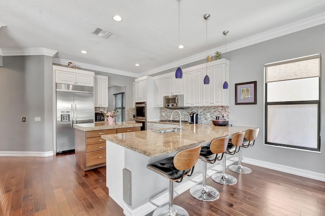 8979 Little Falls Way, Delray Beach, FL 33446 - kitchen with appliances with stainless steel finishes, baseboards, dark wood-style floors, a peninsula, and ornamental molding