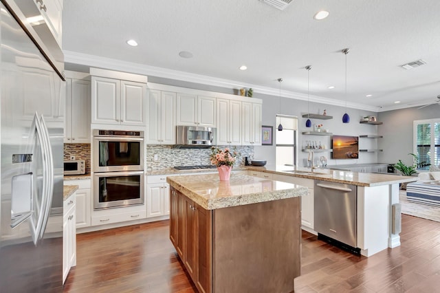 8979 Little Falls Way, Delray Beach, FL 33446 - kitchen with appliances with stainless steel finishes, a peninsula, a sink, backsplash, and dark wood-style floors