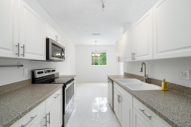 4718 NW 59th Mnr, Coconut Creek, FL 33073 - kitchen with appliances with stainless steel finishes, a sink, white cabinetry, a chandelier, and a textured ceiling