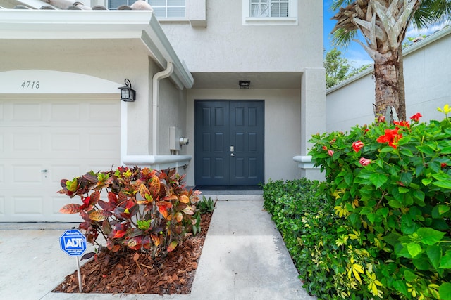 4718 NW 59th Mnr, Coconut Creek, FL 33073 - view of exterior entry with stucco siding and a garage