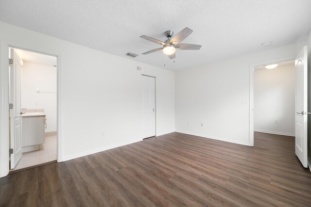 4718 NW 59th Mnr, Coconut Creek, FL 33073 - unfurnished bedroom with wood finished floors, a textured ceiling, baseboards, a ceiling fan, and ensuite bath