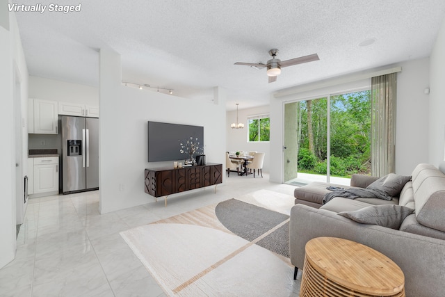 4718 NW 59th Mnr, Coconut Creek, FL 33073 - living room with a ceiling fan, light marble finish floors, a chandelier, rail lighting, and a textured ceiling