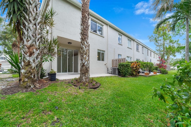 4718 NW 59th Mnr, Coconut Creek, FL 33073 - back of house featuring stucco siding, a yard, and central AC unit