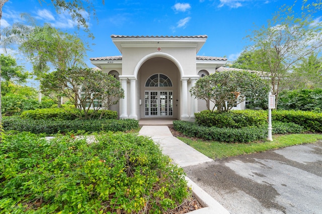 4718 NW 59th Mnr, Coconut Creek, FL 33073 - entrance to property featuring french doors, a tiled roof, and stucco siding
