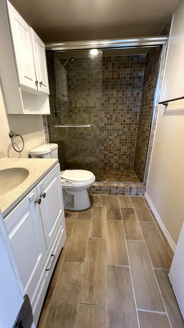 4345 Trevi Ct Unit 208, Lake Worth, FL 33467 - bathroom with wood tiled floors, a stall shower, toilet, and vanity