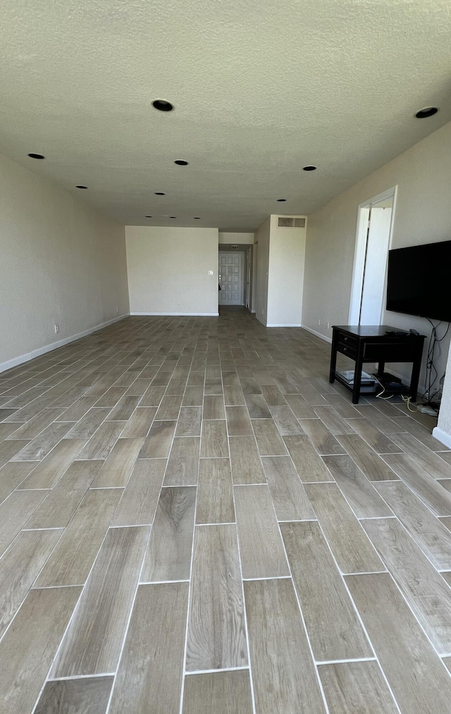 4345 Trevi Ct Unit 208, Lake Worth, FL 33467 - unfurnished living room featuring wood tiled floors, a textured ceiling, and baseboards