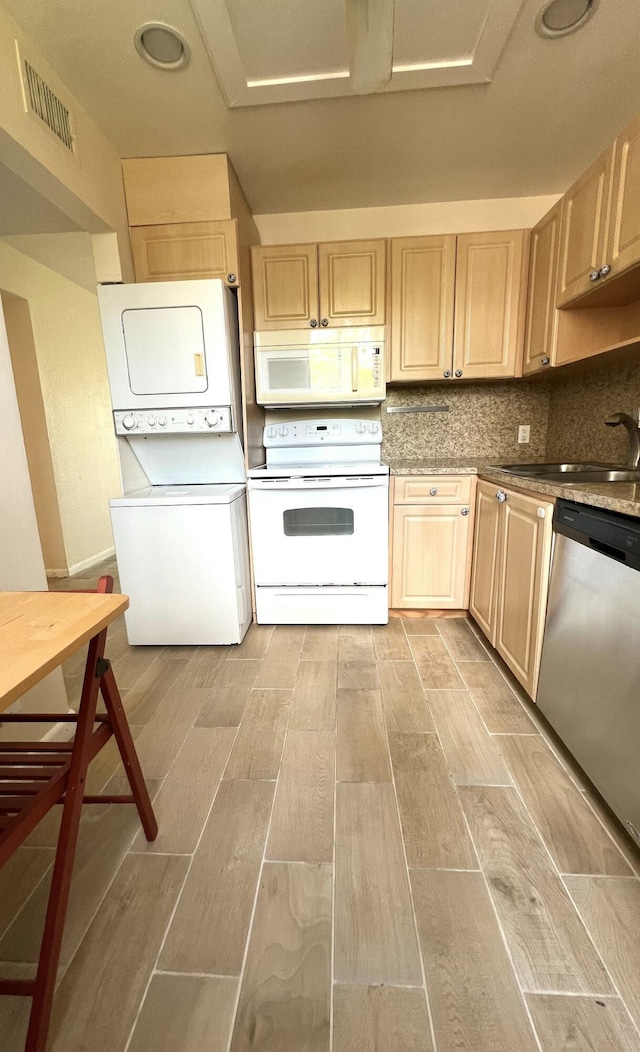 4345 Trevi Ct Unit 208, Lake Worth, FL 33467 - kitchen with white appliances, stacked washing machine and dryer, and light brown cabinetry