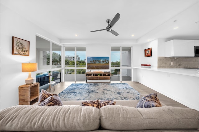 living area featuring a ceiling fan, light wood finished floors, and recessed lighting