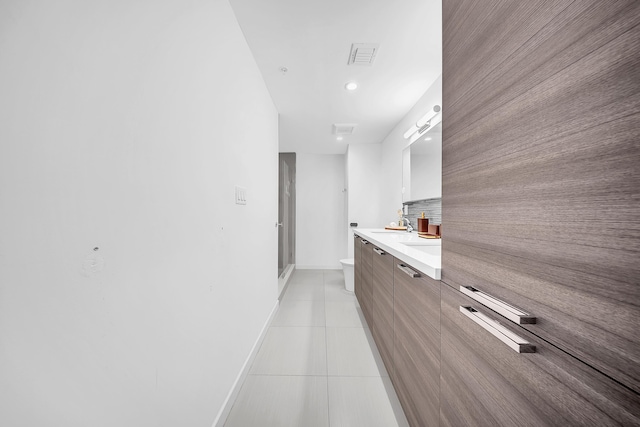 bathroom featuring toilet, a stall shower, tile patterned flooring, vanity, and baseboards