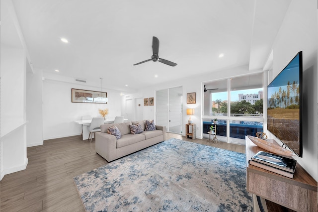 living area with a ceiling fan, wood finished floors, recessed lighting, and baseboards
