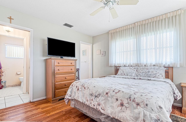 bedroom featuring multiple windows, wood finished floors, ceiling fan, and baseboards
