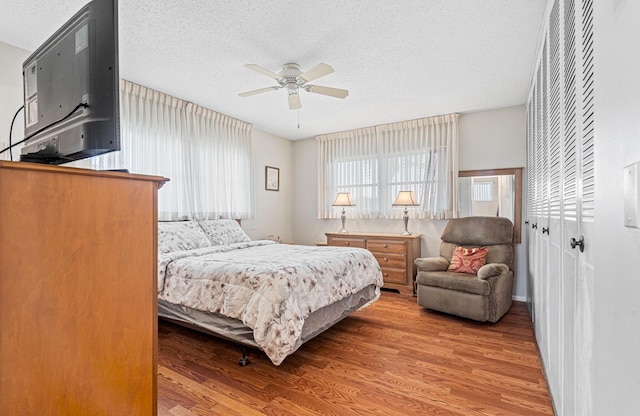 bedroom featuring wood finished floors, a textured ceiling, and ceiling fan