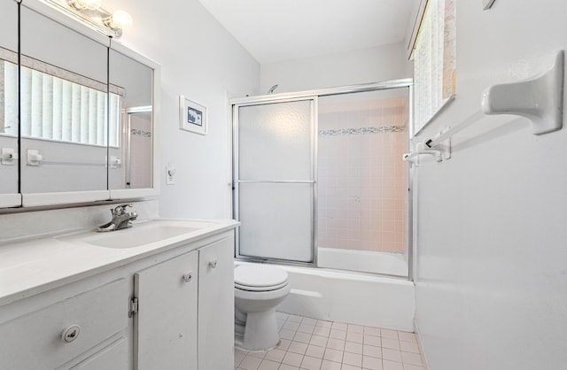bathroom with tile patterned flooring, toilet, vanity, and enclosed tub / shower combo