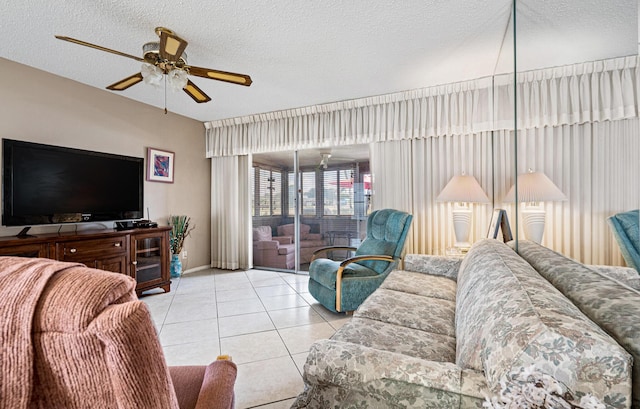tiled living room with a ceiling fan, a textured ceiling, and baseboards