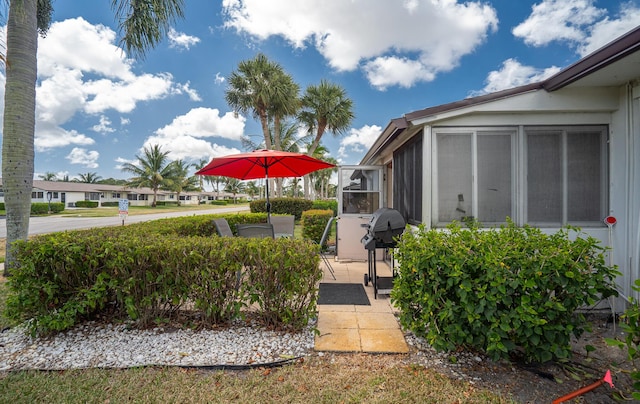view of yard with a sunroom and a patio