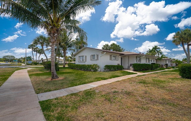 single story home featuring a front yard and stucco siding