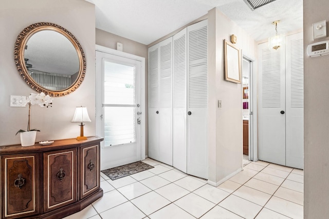 foyer featuring baseboards and light tile patterned flooring