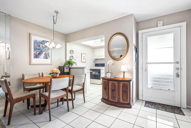 dining area with healthy amount of natural light, light tile patterned flooring, a chandelier, a glass covered fireplace, and a textured ceiling