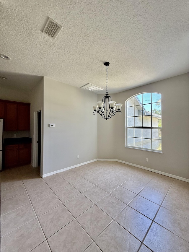 1744 SW Nantucket Ave, Port Saint Lucie, FL 34953 - unfurnished dining area with light tile patterned floors, a chandelier, a textured ceiling, and baseboards