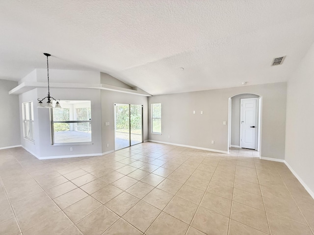 1744 SW Nantucket Ave, Port Saint Lucie, FL 34953 - spare room with light tile patterned floors, vaulted ceiling, a textured ceiling, arched walkways, and a chandelier