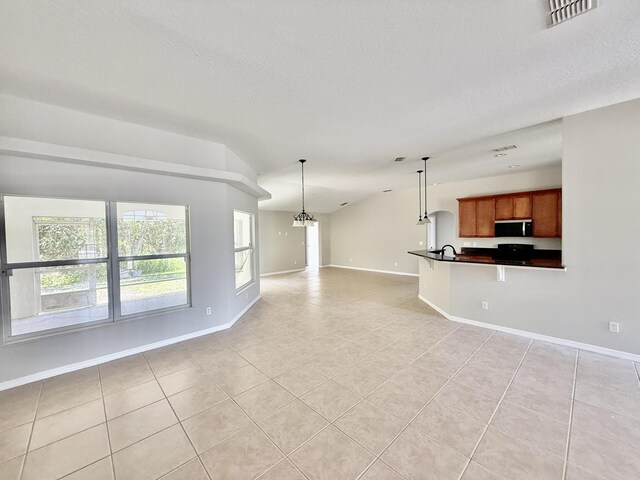 1744 SW Nantucket Ave, Port Saint Lucie, FL 34953 - unfurnished living room featuring light tile patterned flooring, lofted ceiling, baseboards, a textured ceiling, and a chandelier