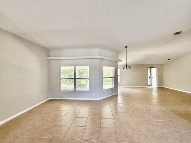 1744 SW Nantucket Ave, Port Saint Lucie, FL 34953 - empty room featuring light tile patterned floors, baseboards, arched walkways, and a chandelier