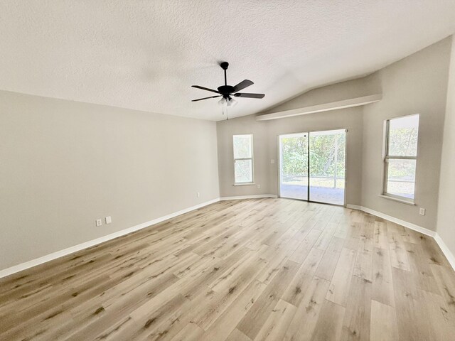 1744 SW Nantucket Ave, Port Saint Lucie, FL 34953 - empty room with light wood-style floors, vaulted ceiling, a ceiling fan, a textured ceiling, and baseboards
