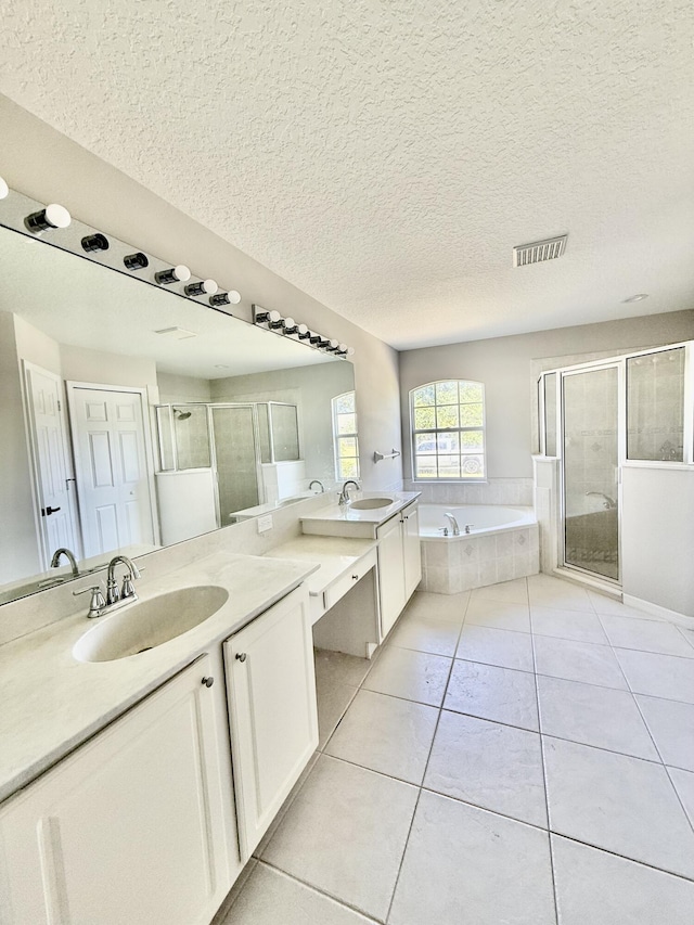 1744 SW Nantucket Ave, Port Saint Lucie, FL 34953 - bathroom with a stall shower, tile patterned floors, a garden tub, a textured ceiling, and double vanity