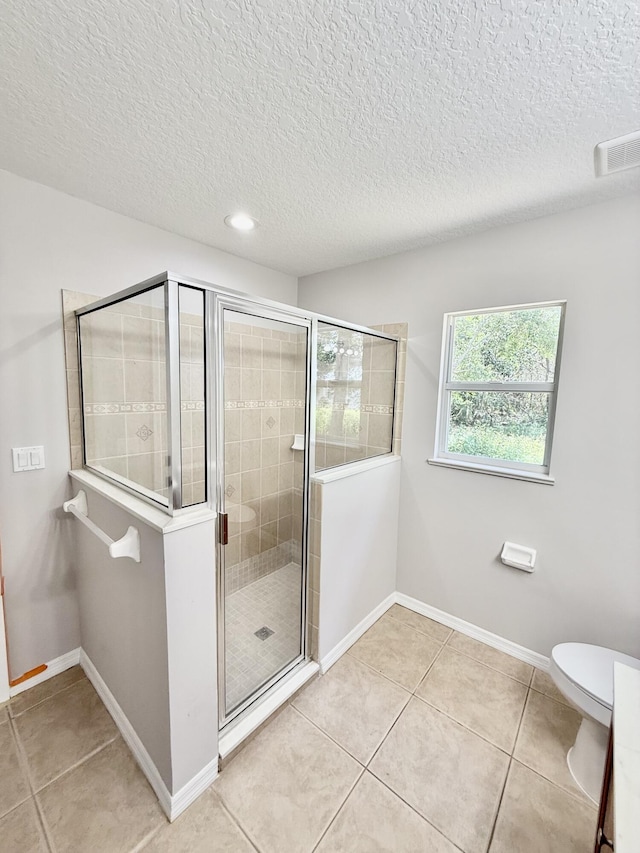 1744 SW Nantucket Ave, Port Saint Lucie, FL 34953 - bathroom featuring a shower stall, tile patterned flooring, baseboards, a textured ceiling, and toilet