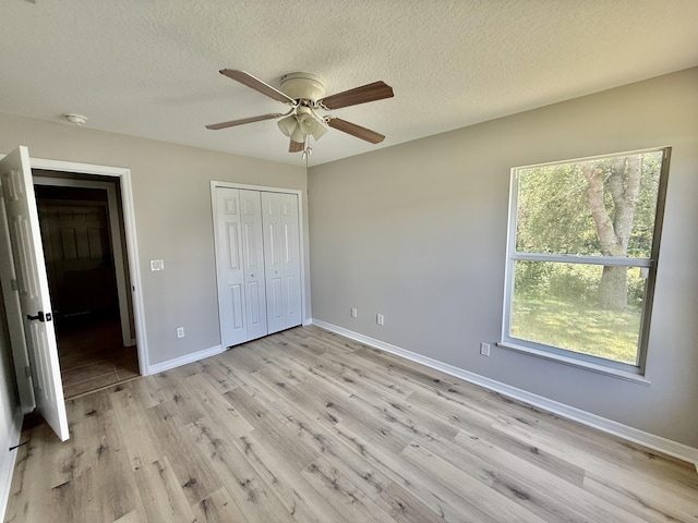 1744 SW Nantucket Ave, Port Saint Lucie, FL 34953 - unfurnished bedroom featuring baseboards, light wood finished floors, a textured ceiling, a closet, and a ceiling fan