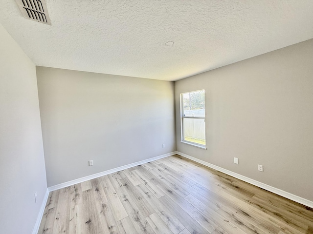 1744 SW Nantucket Ave, Port Saint Lucie, FL 34953 - unfurnished room with light wood-type flooring, baseboards, and a textured ceiling