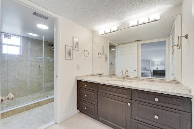 6698 10th Ave N Unit 320, Lake Worth, FL 33467 - ensuite bathroom with a shower stall, vanity, tile patterned floors, a textured ceiling, and baseboards