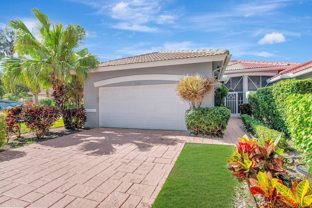 9564 Crescent View Dr N, Boynton Beach, FL 33437 - view of front of property with an attached garage, stucco siding, decorative driveway, a tile roof, and a front lawn