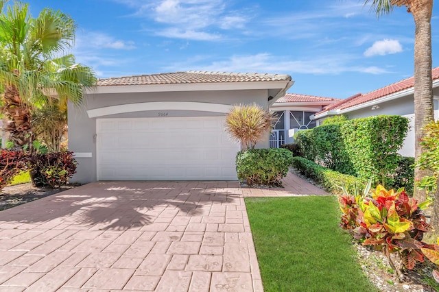 9564 Crescent View Dr N, Boynton Beach, FL 33437 - mediterranean / spanish-style home featuring a tile roof, stucco siding, decorative driveway, a garage, and a front lawn