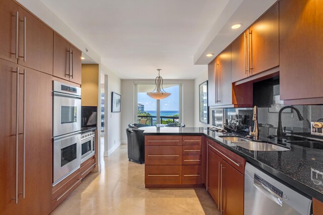 901 E Camino Real Unit 7C, Boca Raton, FL 33432 - kitchen featuring appliances with stainless steel finishes, a sink, tasteful backsplash, a peninsula, and dark stone counters
