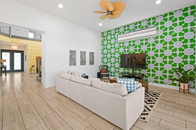 16323 Pantheon Pass, Delray Beach, FL 33446 - living room with wallpapered walls, an accent wall, baseboards, wood finish floors, and ceiling fan