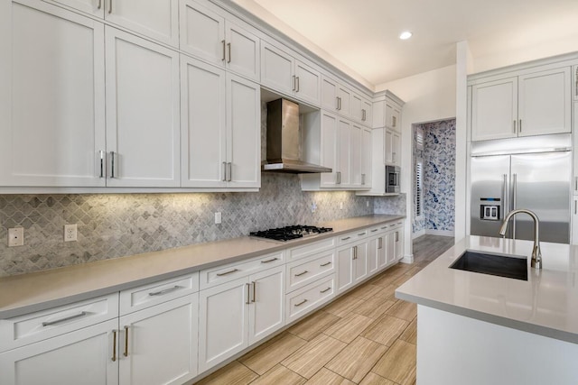 16323 Pantheon Pass, Delray Beach, FL 33446 - kitchen with wall chimney range hood, built in appliances, a sink, light countertops, and backsplash