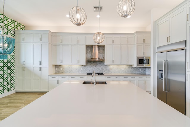 16323 Pantheon Pass, Delray Beach, FL 33446 - kitchen with built in appliances, wall chimney exhaust hood, light countertops, and wallpapered walls
