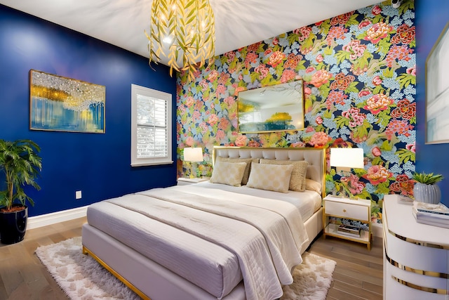 16323 Pantheon Pass, Delray Beach, FL 33446 - bedroom with a chandelier, wallpapered walls, wood finished floors, baseboards, and an accent wall