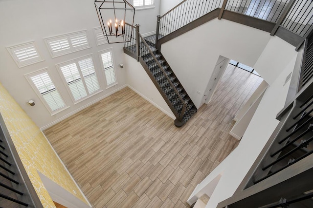16323 Pantheon Pass, Delray Beach, FL 33446 - stairway with a towering ceiling, wood finished floors, a chandelier, and baseboards