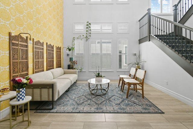 16323 Pantheon Pass, Delray Beach, FL 33446 - living room featuring a high ceiling, baseboards, stairway, wood tiled floors, and wallpapered walls