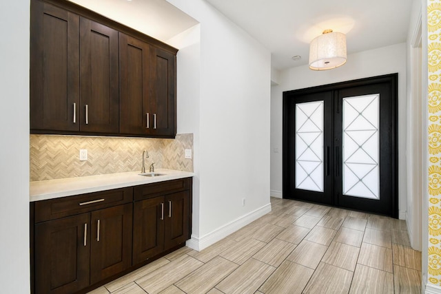 16323 Pantheon Pass, Delray Beach, FL 33446 - bar area with decorative backsplash, a sink, baseboards, wood finish floors, and french doors
