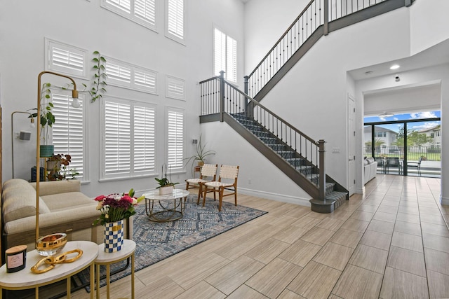 16323 Pantheon Pass, Delray Beach, FL 33446 - living area featuring a towering ceiling, stairs, baseboards, and wood finish floors