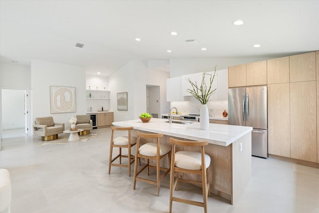 1175 Sea Grape Cir, Delray Beach, FL 33445 - kitchen with freestanding refrigerator, a sink, modern cabinets, a kitchen bar, and lofted ceiling