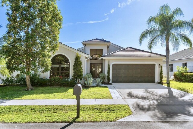 1175 Sea Grape Cir, Delray Beach, FL 33445 - kitchen featuring freestanding refrigerator, modern cabinets, a kitchen bar, a center island with sink, and vaulted ceiling