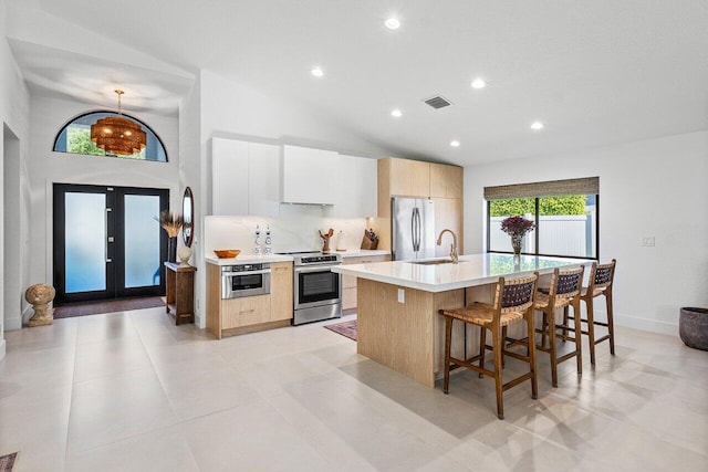 1175 Sea Grape Cir, Delray Beach, FL 33445 - kitchen featuring stainless steel appliances, modern cabinets, a sink, an island with sink, and a kitchen breakfast bar