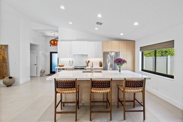 1175 Sea Grape Cir, Delray Beach, FL 33445 - kitchen with appliances with stainless steel finishes, a sink, light countertops, a kitchen bar, and lofted ceiling